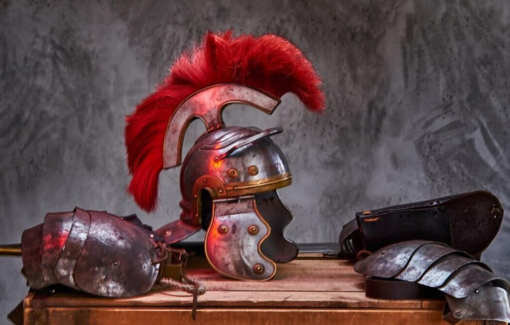 A Roman centurion helmet with red plume displayed on a table
