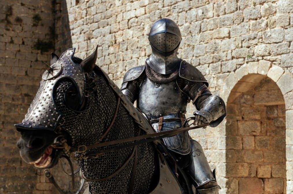 A knight in full armor on a caparisoned horse